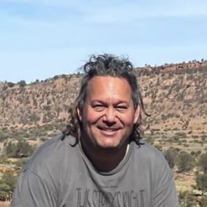 David Doyle, who is smiling in front of a bush landscape.