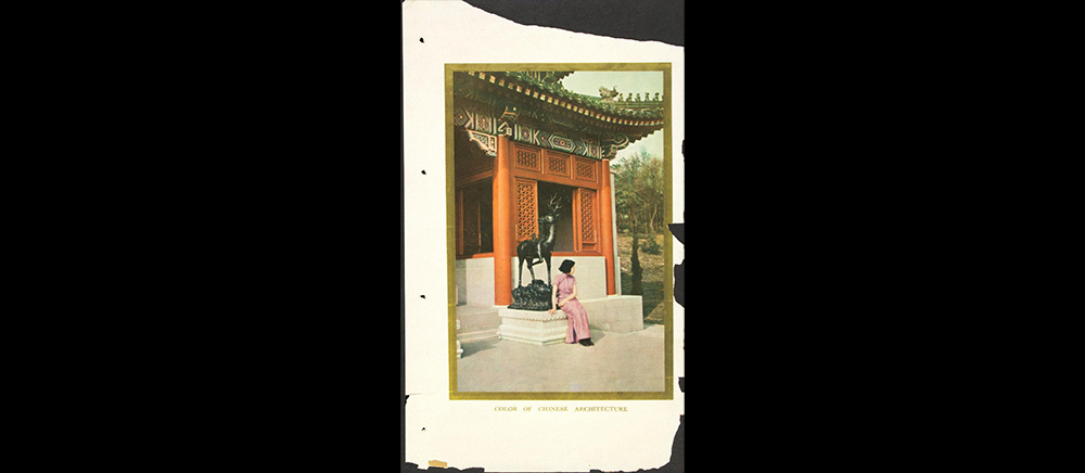 A woman sitting in front of a Chinese temple.