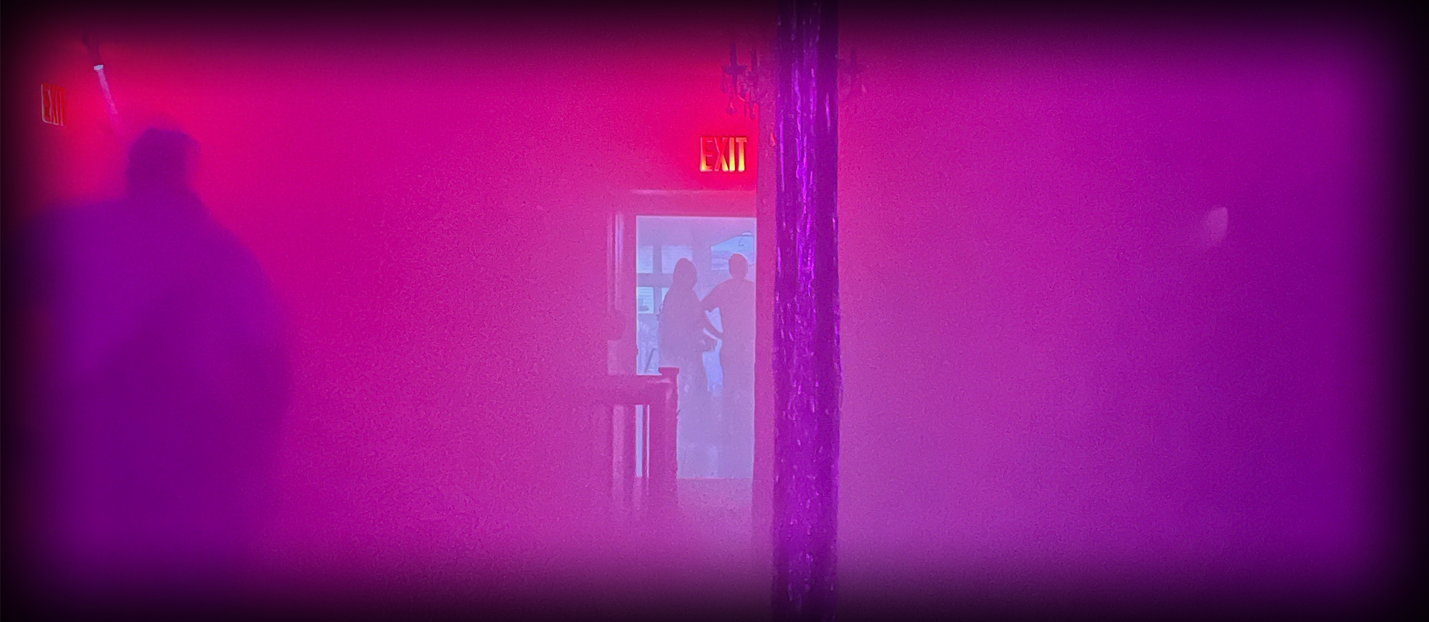 A pink-hued photo of a rave.