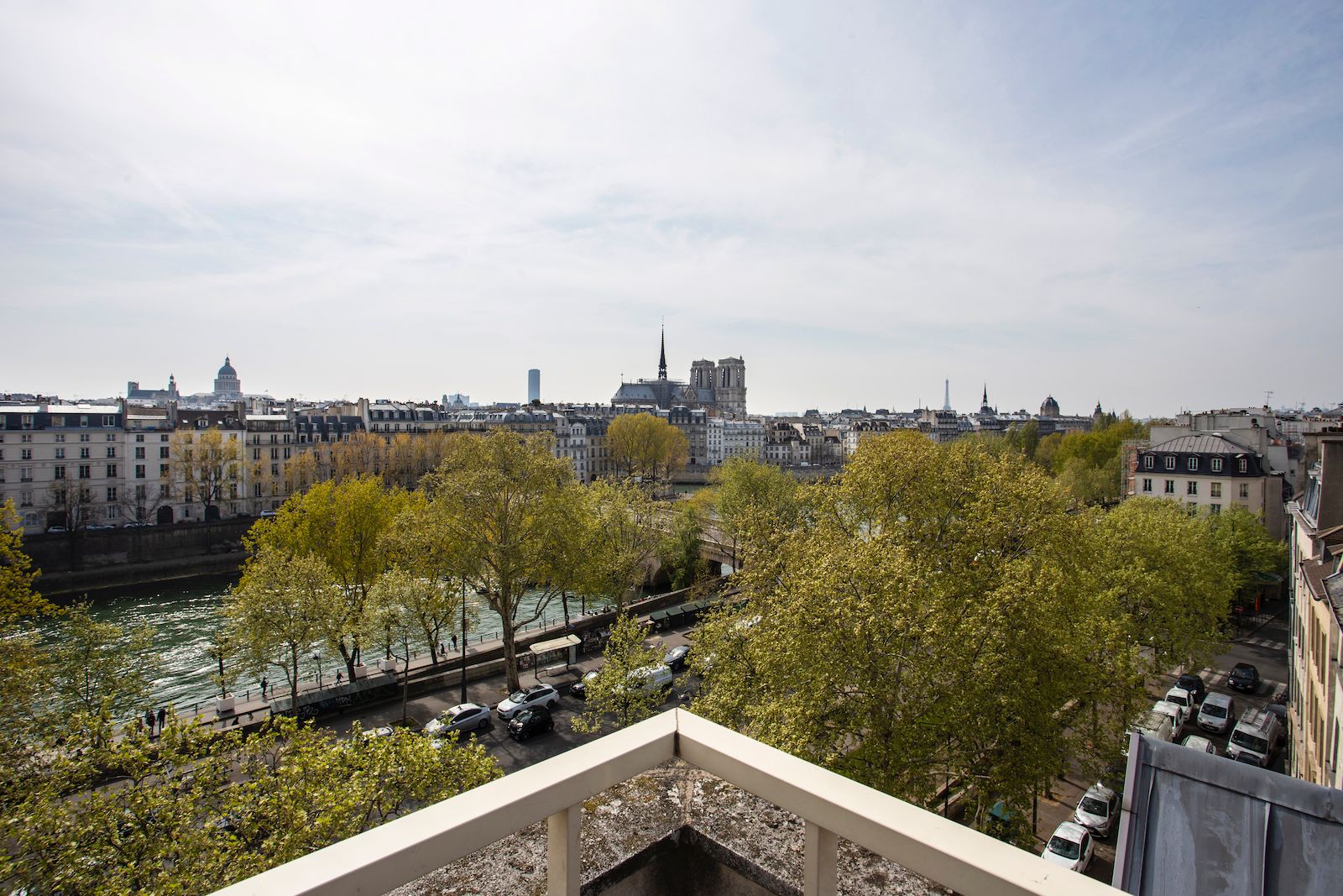 A view of Paris from a balcony showing the River Seine and in the distance the Notre Dame cathedral.