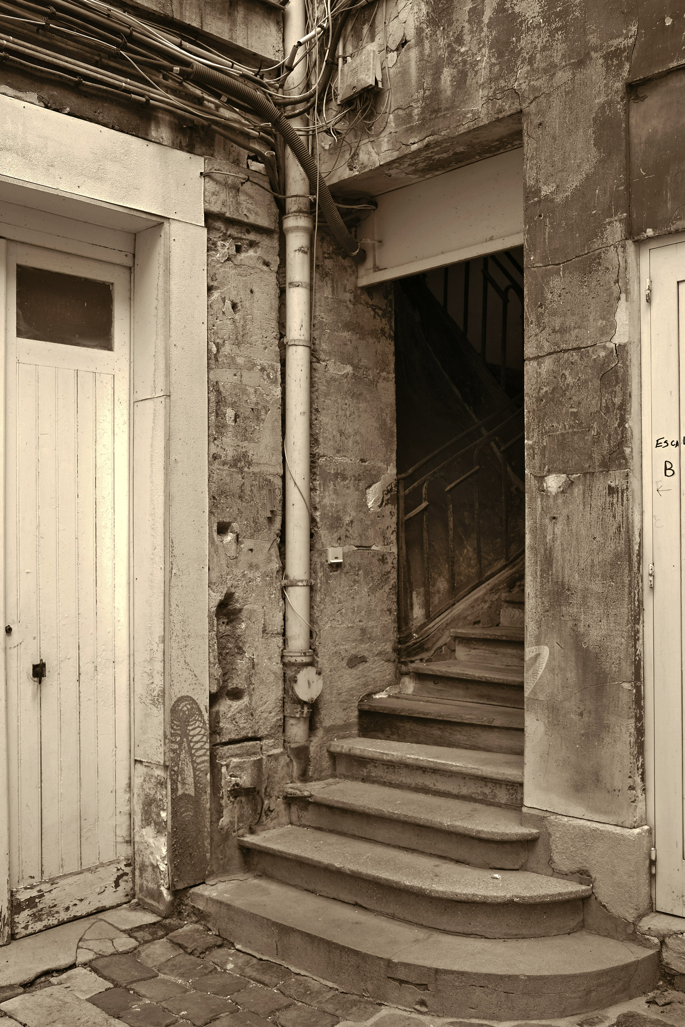 A greyscale image of a corner with stairwell