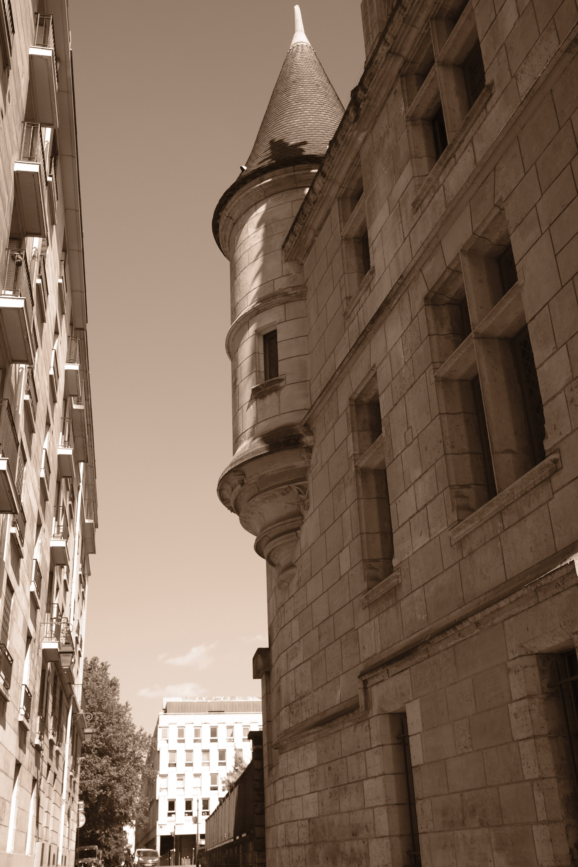 A greyscale photograph of a street with the Cité International des Arts in the background