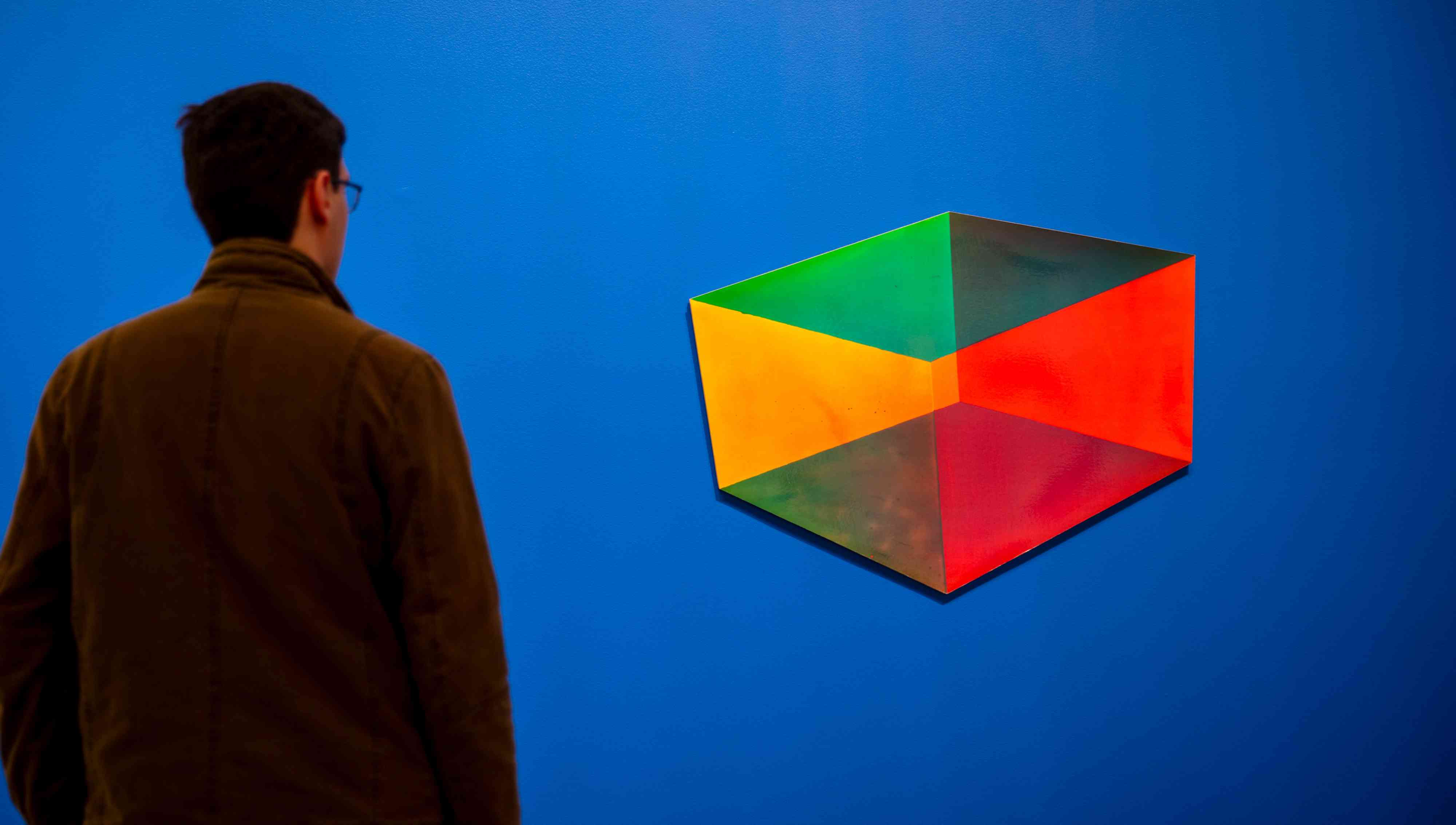 A man looking at an abstract painting.