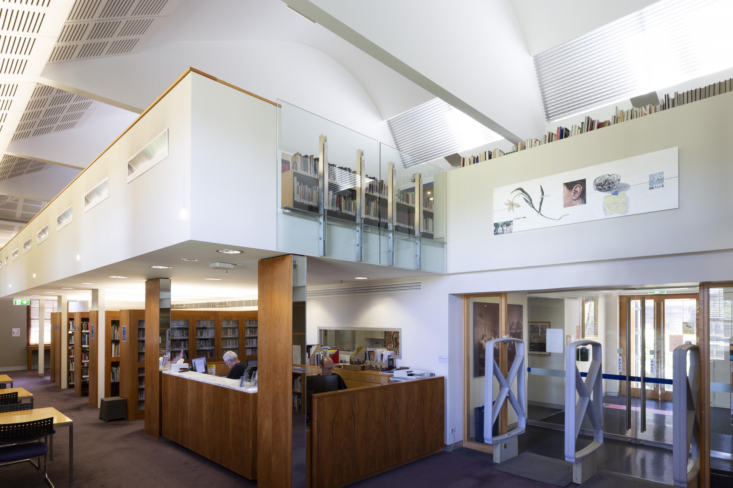 A photograph of the Schaeffer Library, showing a counter staffed by two librarians